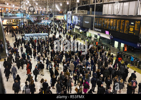 Rush hour commuters wait for the next train arrival information at Waterloo railway station in London. November 2018 Stock Photo