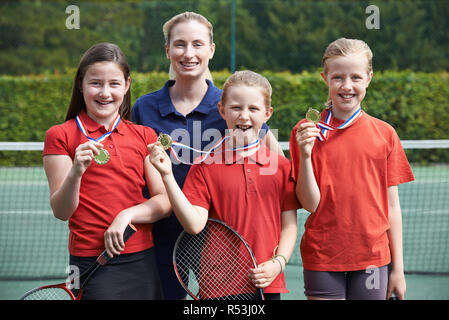 Portrait Of Winning Female School Tennis Team With Medals Stock Photo