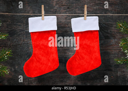 Christmas red socks on rope. Wooden background. Stock Photo