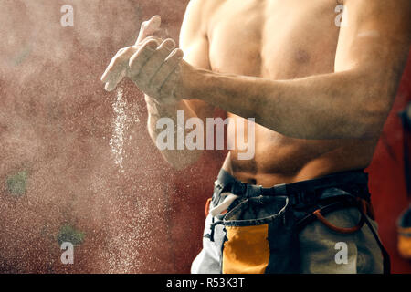 Man coating his hands in powder chalk magnesium preparing to climb, motion Stock Photo