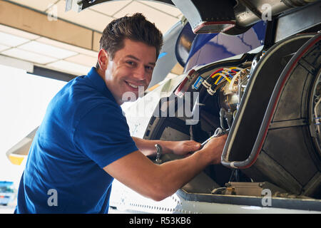 Portrait Of Male Aero Engineer Working On Helicopter In Hangar Stock Photo