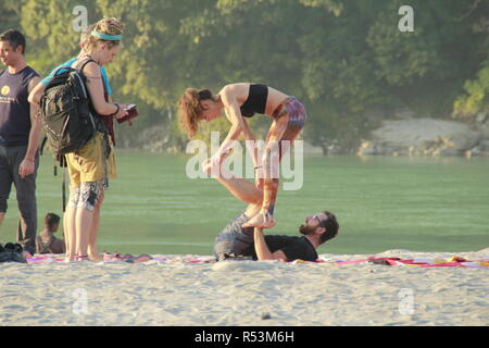 International students performing acro yoga at Ganga Beach, Rishikesh, India Stock Photo