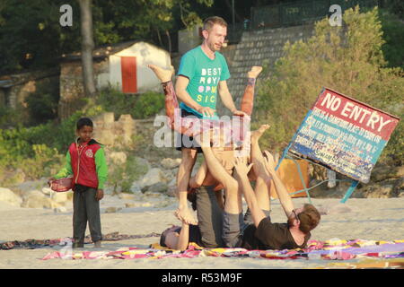 International students performing acro yoga at Ganga Beach, Rishikesh, India Stock Photo