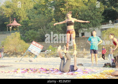 International students performing acro yoga at Ganga Beach, Rishikesh, India Stock Photo