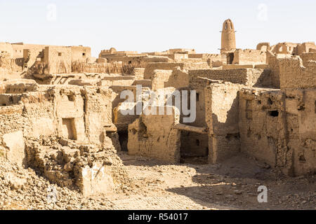 Ruins of ancient arab middle eastern old town built of mud bricks, old mosque with minaret. Al Qasr, Dakhla Oasis, Western Desert, New Valley, Egypt. Stock Photo