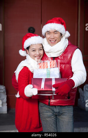 Young couple holding Christmas Gifts Stock Photo