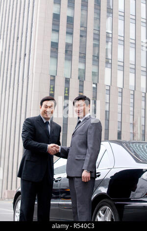 Two businessmen shaking hands outdoors Stock Photo