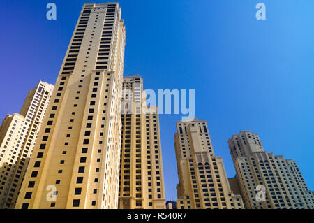 Skyscrapers from below in Dubai against blue sky.  Raising the bar. Stock Photo