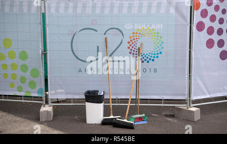 29 November 2018, Argentina, Buenos Aires: Brooms stand in front of a G-20 logo in the International Press Centre in Buenos Aires. From 30.11.-1.12.2018 the G20 summit will take place in Buenos Aires. The 'Group of 20' unites the strongest industrial nations and emerging economies. Photo: Ralf Hirschberger/dpa Stock Photo