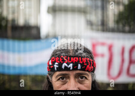 Buenos Aires, Argentina. 28th Dec, 2018. 'Household/IWF/No', is written on the headband of a demonstrator in a protest against the G20 summit that will take place on 30 November and 1 December 2018 in Buenos Aires. The demonstration was also directed against the fiscal policy of the Argentine government. The IMF has pledged billion-dollar loans to Argentina. The government of the liberal President Macri is already under pressure because the country has slipped into a deep crisis with high inflation. Credit: Nicolas Villalobos/dpa/Alamy Live News Stock Photo