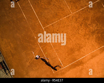 Shot of a young male athlete training on a race track. Sprinter running on athletics tracks seen from above. Stock Photo