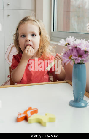 A young girl eating string cheese Stock Photo