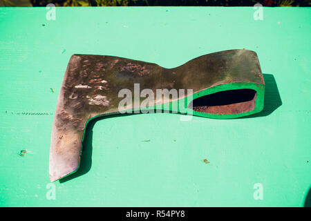Rusty tip of sharp ax lies on edging boards Stock Photo