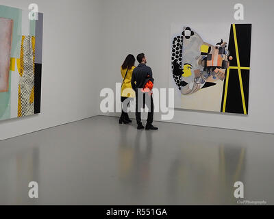 Couple looking at artwork on wall in museum room Stock Photo
