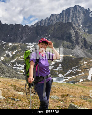 Smiling hiker with a backpack on background of mountain Siberian tundra. East Sayan. Russia Stock Photo