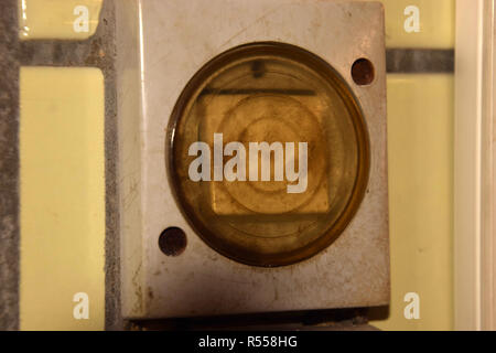 outdated dirty light switch on a tiled wall in a stable, old and dirty light switches with plastic cover protected against moisture and wet Stock Photo