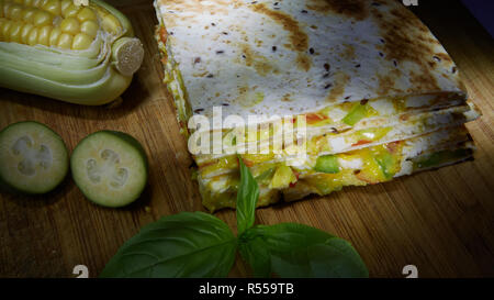 Mexican quesadilla with chicken, cheese and peppers on wooden table Stock Photo