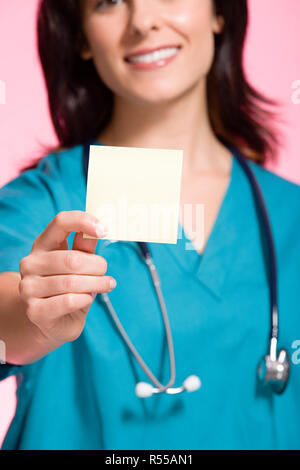 Female nurse holding an adhesive note Stock Photo