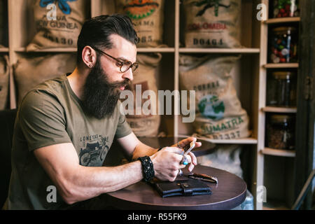 Young hipster writing a sms in a bar Stock Photo