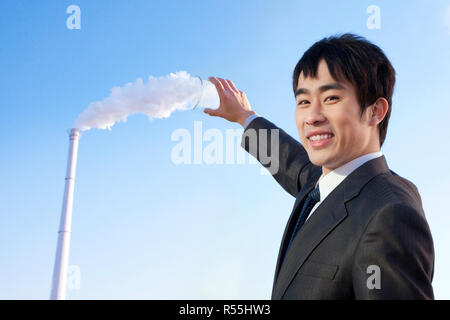 Businessman Collecting Smoke in Beaker Stock Photo