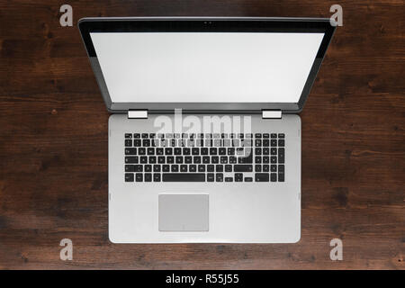 Top view of laptop on desk, dark brown wooden workspace Stock Photo