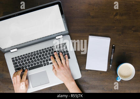 Top view of man working on computer with coffee and notepad Stock Photo
