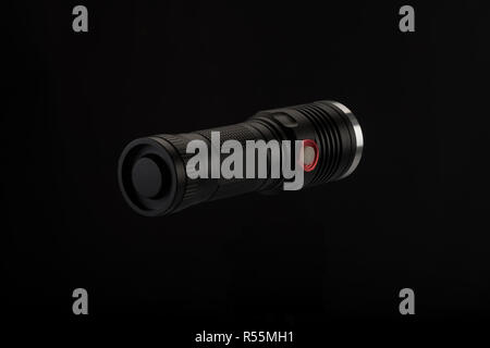 Tactical flashlight, hand on black background, studio light Stock Photo