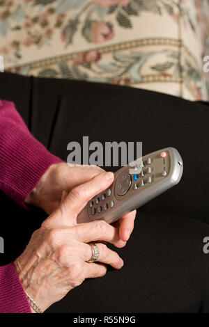 Senior woman using remote control Stock Photo