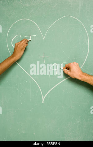 Two students drawing on blackboard Stock Photo