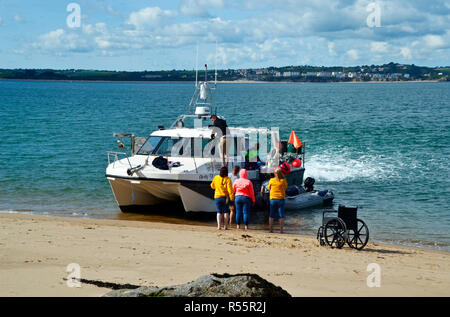 Disabled person manouvring from wheelchair to boat on Caldey Island, near Tenby, Wales, UK Stock Photo