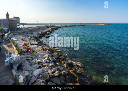 People enjoying summer on the beach near Trani port. Trani, Apulia, August 2017 Stock Photo