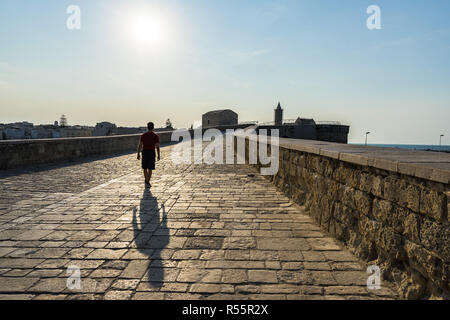 Unidentified man walking on Trani's pier at sunset, Apulia, Italy Stock Photo