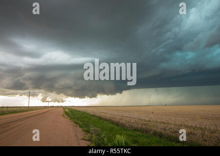 A wall cloud forms underneath a tornadic supercell thunderstorm as it gathers strength. Stock Photo