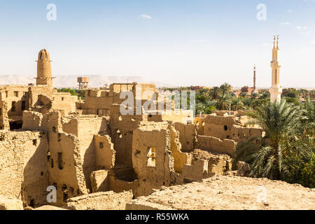 Oasis. Ruins of ancient middle eastern Arab town built of mud bricks, old mosque with minaret. Al Qasr, Dakhla Oasis, Western Desert, Egypt, Africa. Stock Photo