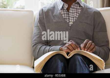 Blind man reading a braille book Stock Photo