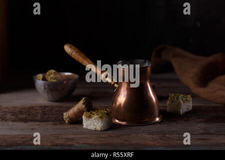 Copper coffee pot with oriental delights on dark background, copy space Stock Photo
