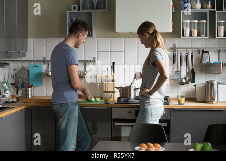 Young man and woman, couple cooking together in kitchen Stock Photo