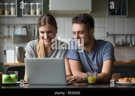 Happy smiling couple looking at laptop screen together Stock Photo