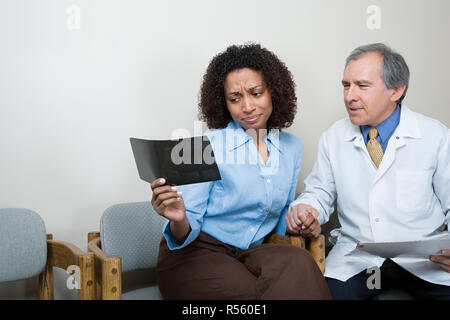 Dentist showing patient x ray Stock Photo
