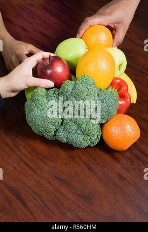 People taking fruit from table Stock Photo