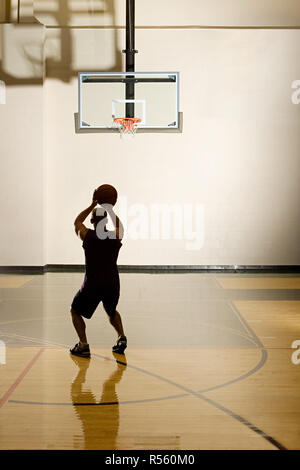 Man aiming for basketball hoop Stock Photo