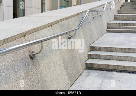 stainless steel metal handrails on stone steps Stock Photo