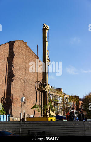 DNIPRO, UKRAINE - NOVEMBER 1, 2018: Workers at a construction site in the city center. Special equipment for piling works near the side facade of the  Stock Photo