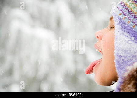 Girl in snow sticking out tongue Stock Photo