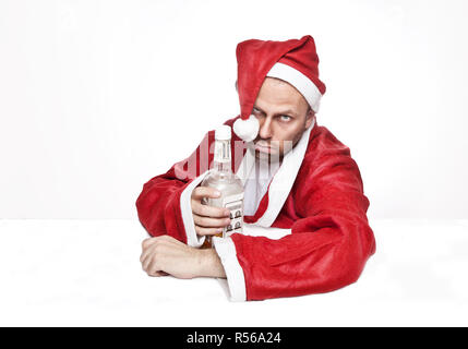 Man in Santa Claus costume with a bottle of whiskey Stock Photo