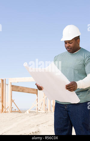 A builder holding a blueprint Stock Photo