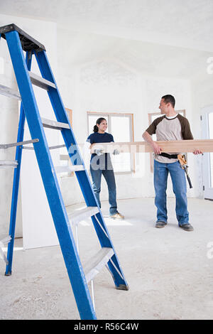 A couple holding a plank of wood Stock Photo