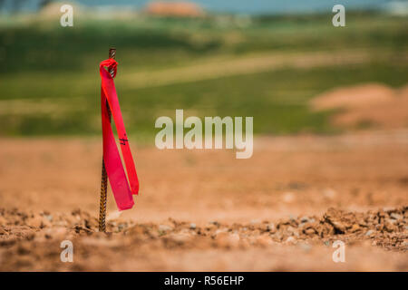 Metal survey peg with red flag on construction site Stock Photo