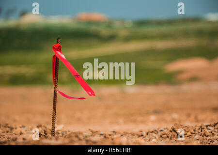 Metal survey peg with red flag on construction site Stock Photo