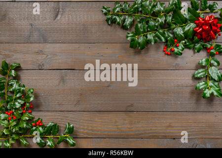Christmas holly with Berries on a wood background Stock Photo